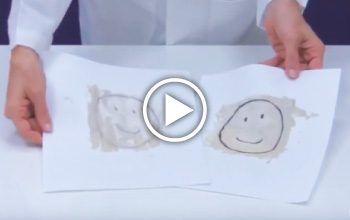 A Mad Science instructor holding a paper with 2 smiley faces.